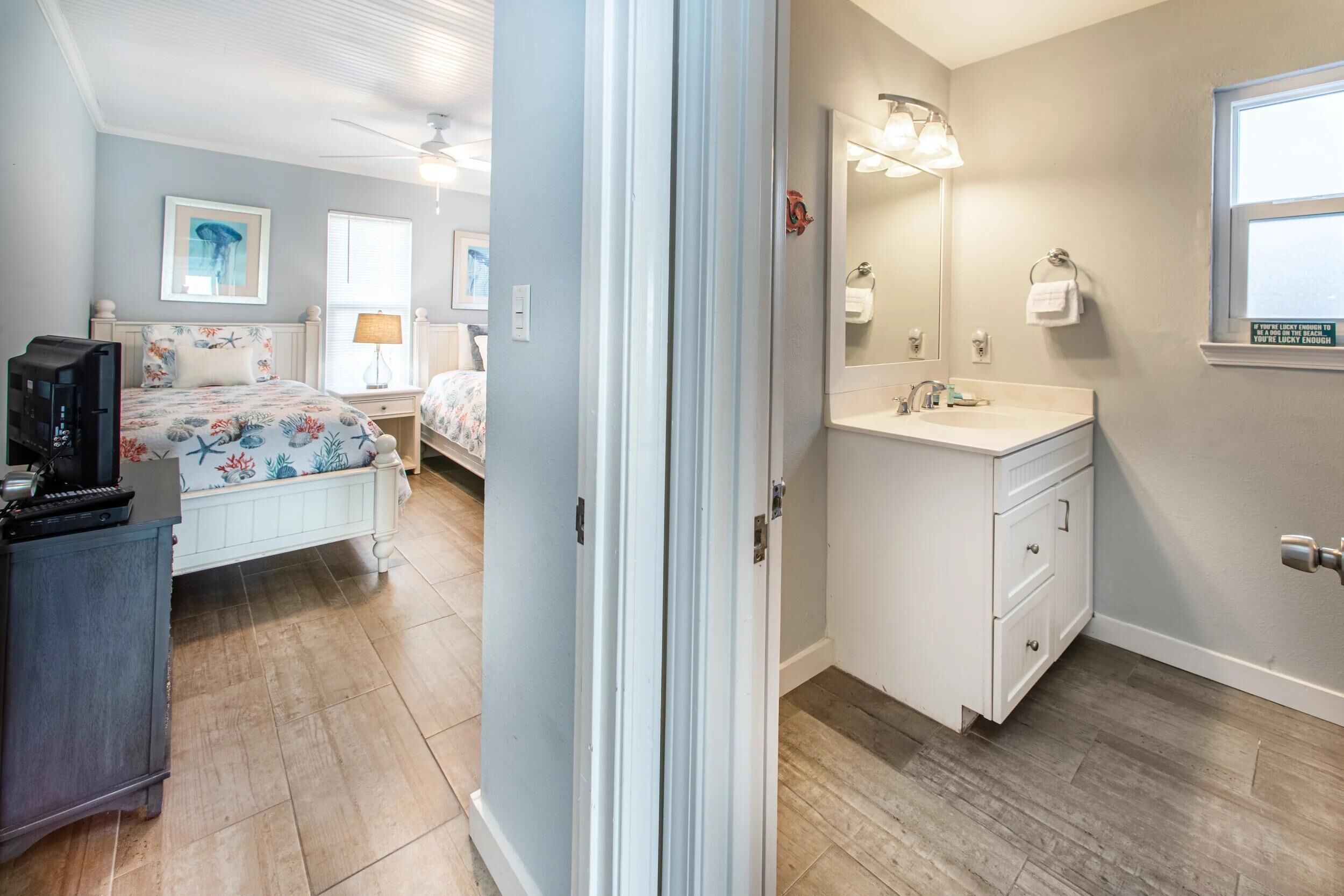 Un dormitorio con una cama, un aparador y un mueble para la televisión.