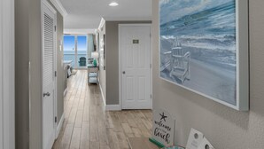 A hallway with a view of the beach, a welcome sign, and a door. - Majestic Beach Towers 1-1804 (Panama City Beach)