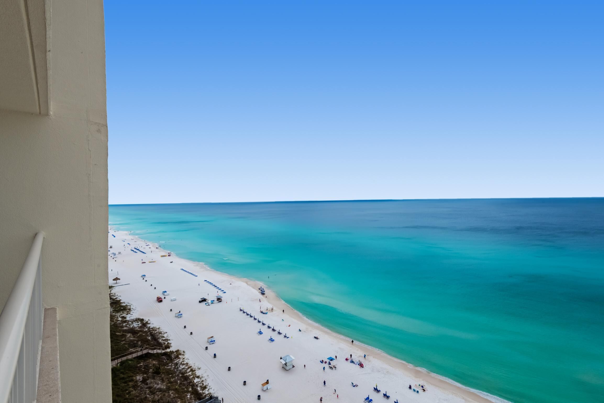 A beach with clear turquoise waters and a white sandy shore.