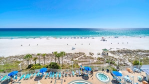 A beach resort with a pool area, sun loungers, and a view of the ocean. - Boardwalk 508 (Panama City Beach)