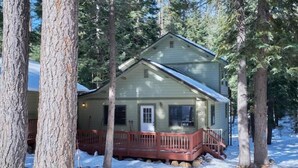A two-story house with a red porch and a snow-covered yard.