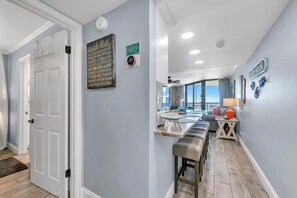 Una cocina moderna con barra, vista a la playa y un letrero que dice "Beach Rules".