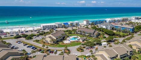 Vista aérea de un hotel costero con varias construcciones, una piscina y una zona de playa.
