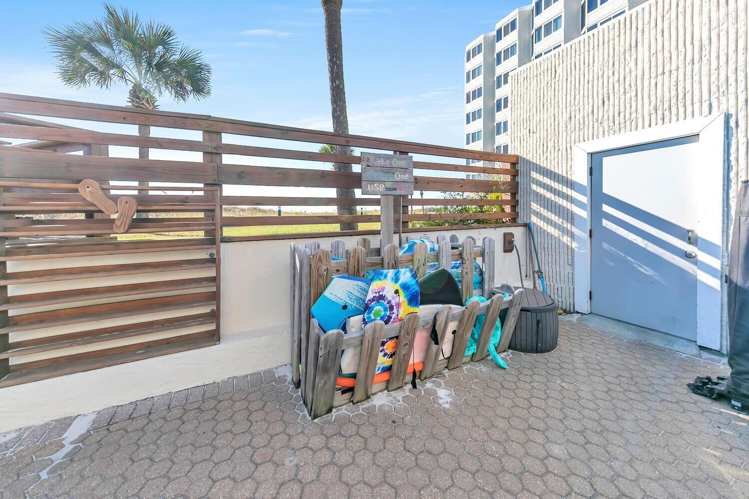 A fenced outdoor area with a wooden bench and a signpost.