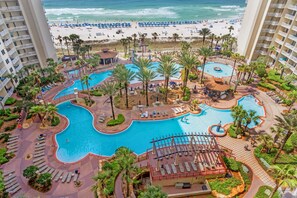 A resort with multiple swimming pools, palm trees, and a beach view. - Shores of Panama 1117 (Panama City Beach)