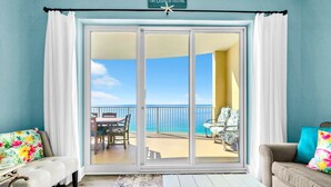 Ein Zimmer mit einer Schiebetür und einem Balkon mit Meerblick.