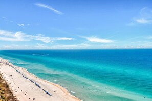 A beach with clear turquoise waters and a sandy shore. - Ocean Villa 2303 (Panama City Beach)