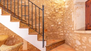 A staircase with ornate railings and patterned steps, leading to a room with stone walls and a wooden cabinet. - S'ALQUERIA ROTJA - Magnificent 17th-century estate with a pool in Santanyí (Santanyí)