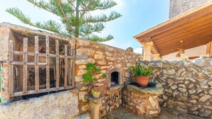 A stone wall with a wooden window, a small wooden structure, and potted plants. - S'ALQUERIA ROTJA - Magnificent 17th-century estate with a pool in Santanyí (Santanyí)