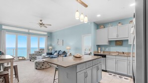 A spacious kitchen with a large island, light blue cabinetry, and a view to the outside. - Laketown Wharf Penthouse 2026 (Panama City Beach)
