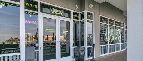 A building with a sign for 'Gunner's Joint' and 'Pool' visible through the glass doors.