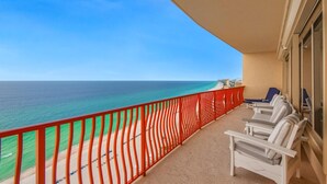 A balcony with a view of the ocean, a red railing, and several lounge chairs. - Hidden Dunes 1803 (Panama City Beach)