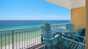 Ein Balkon mit Blick auf das Meer, ausgestattet mit einem Tisch und Stühlen.