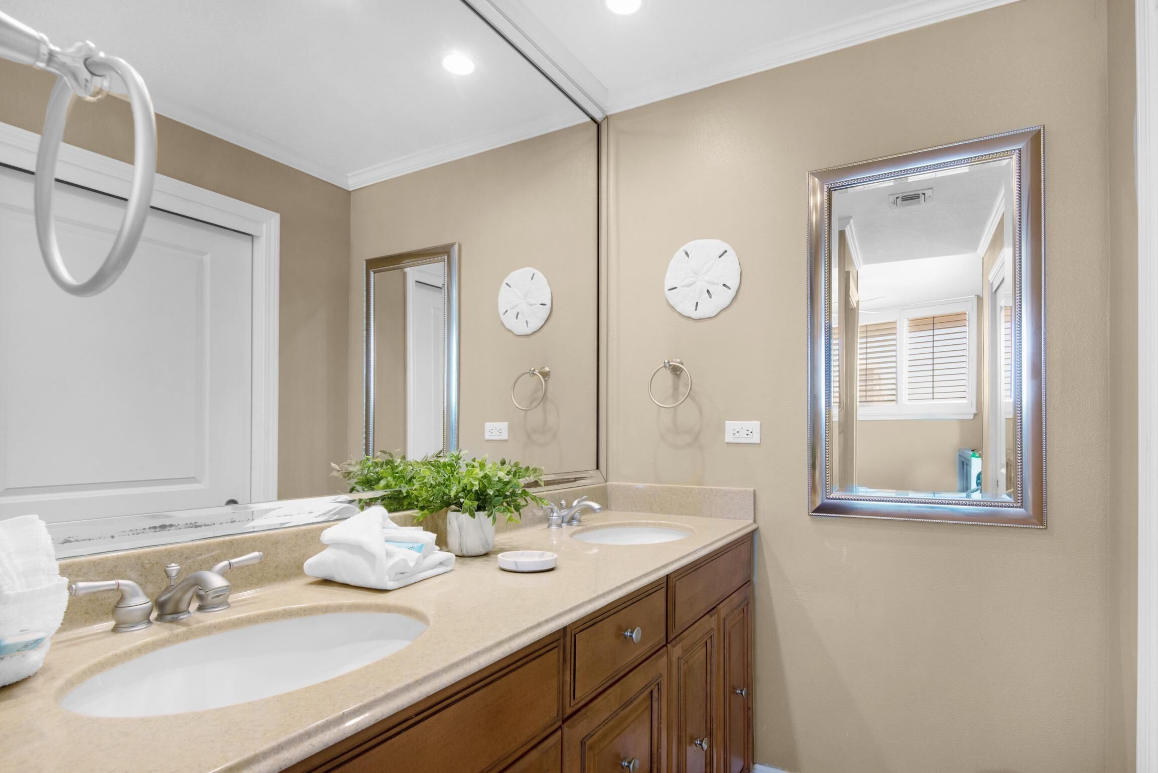 A bathroom with two sinks, a mirror, and a ring light.