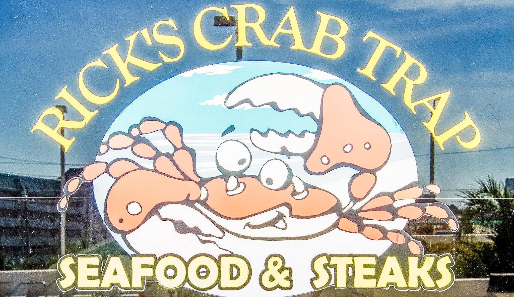 Placa para o Rick's Crab Trap, destacando frutos do mar e bifes.
