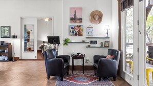 A living room with two black leather chairs, a patterned rug, and artwork on the wall. - Cozy Guest House on Fitzhugh Rd in the Hill Country, 14 miles to downtown Austin (Austin)