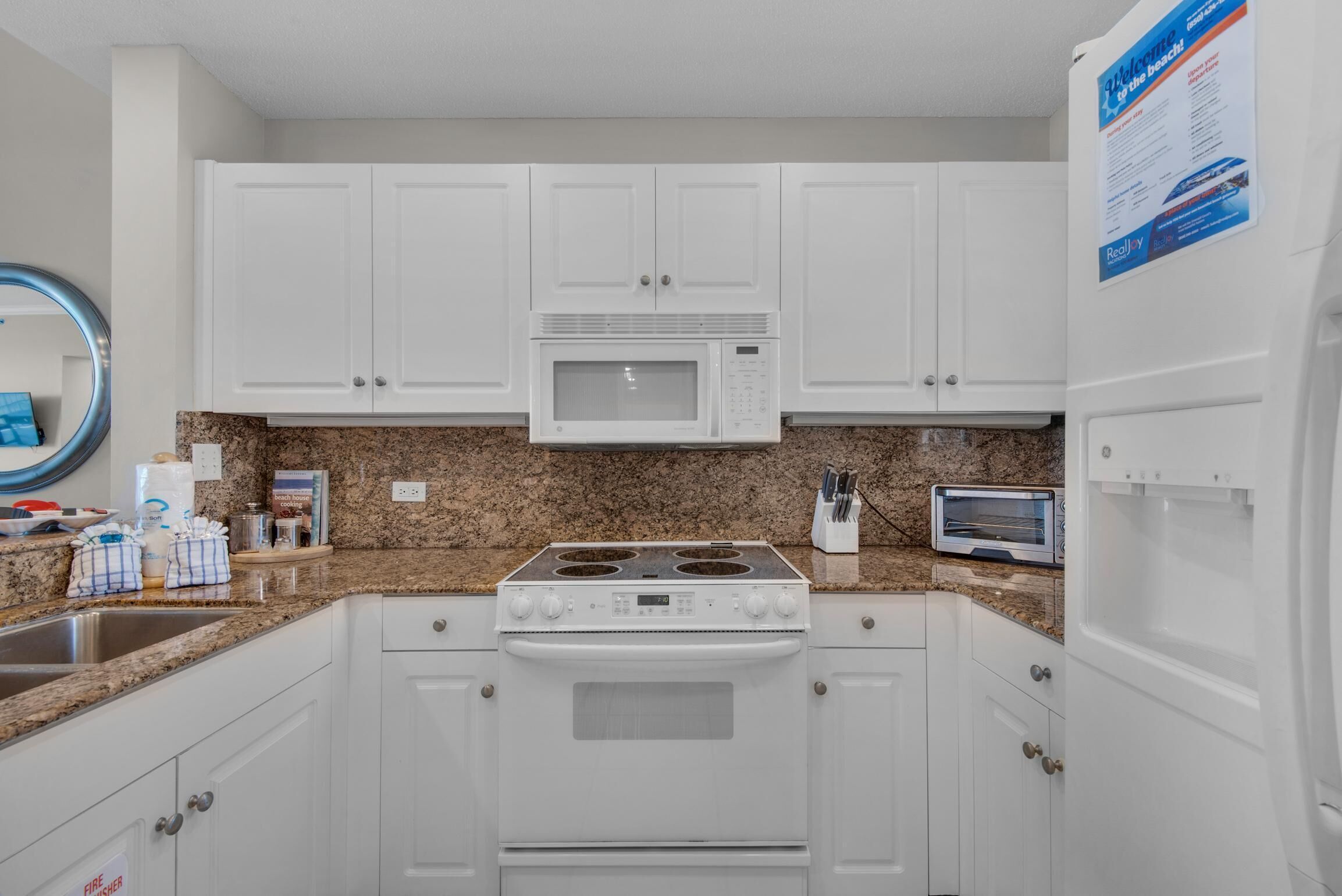 A kitchen with white cabinets, a microwave, a stove, and a toaster.