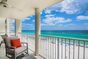 Un balcon avec vue sur une plage et l’océan.