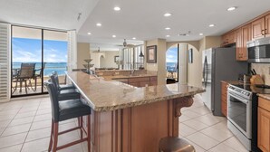 A spacious kitchen with a large island, stainless steel appliances, and a view to the outside. - East Pass 309 (Destin)
