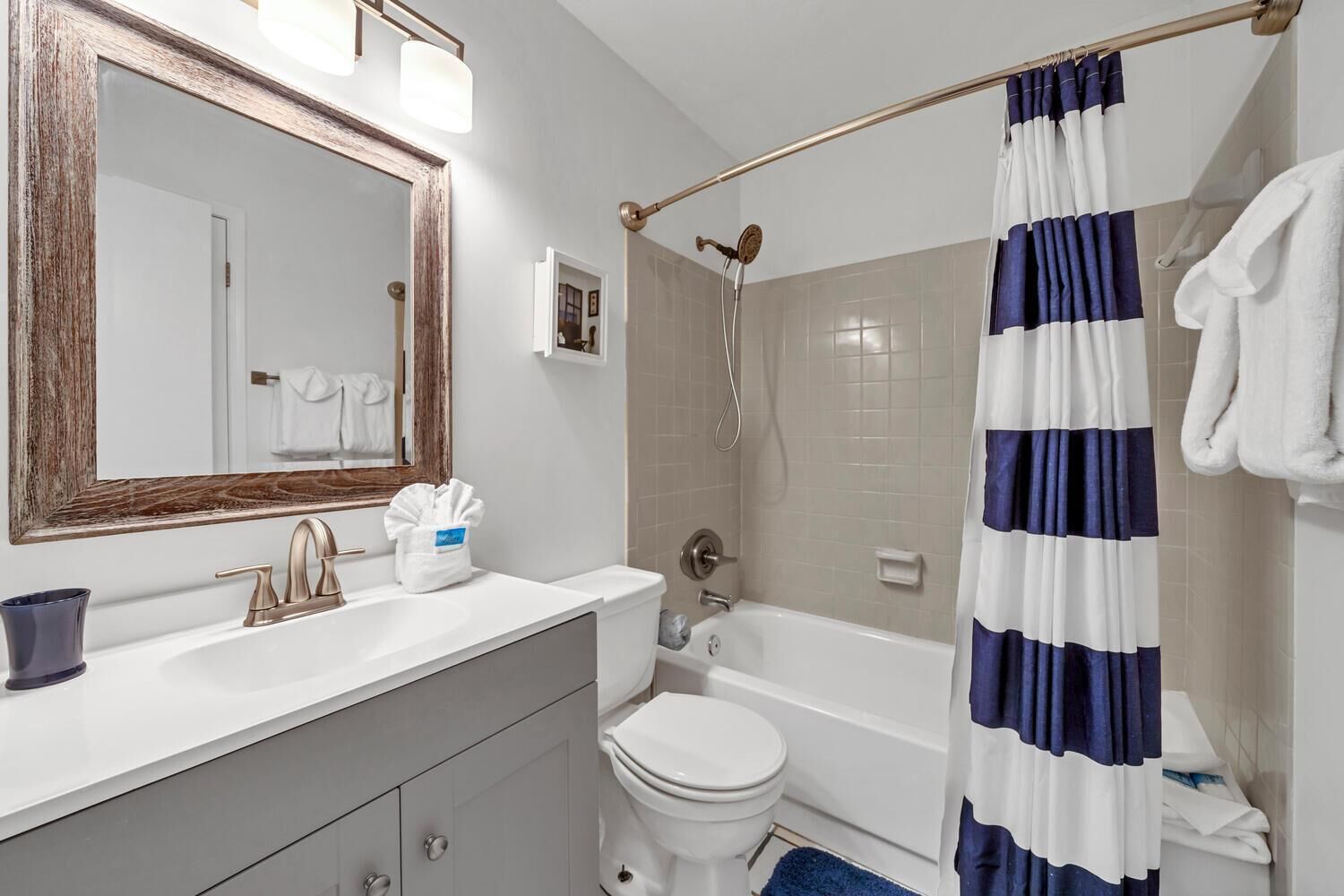 A bathroom with a white sink, a toilet, a bathtub, and a shower curtain.
