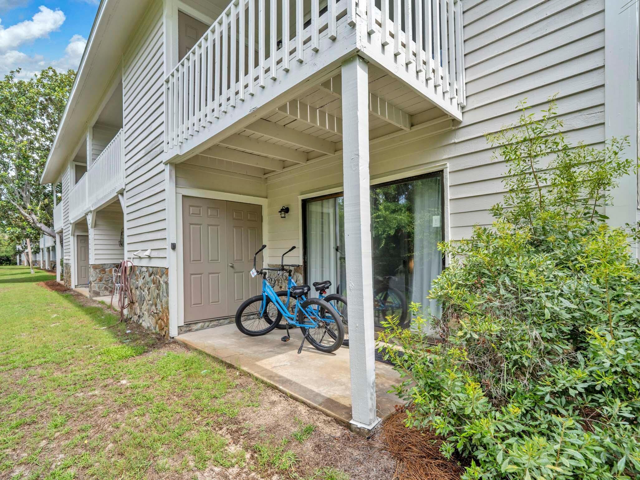 A two-story building with a covered porch, a bicycle parked outside, and a well-maintained lawn.