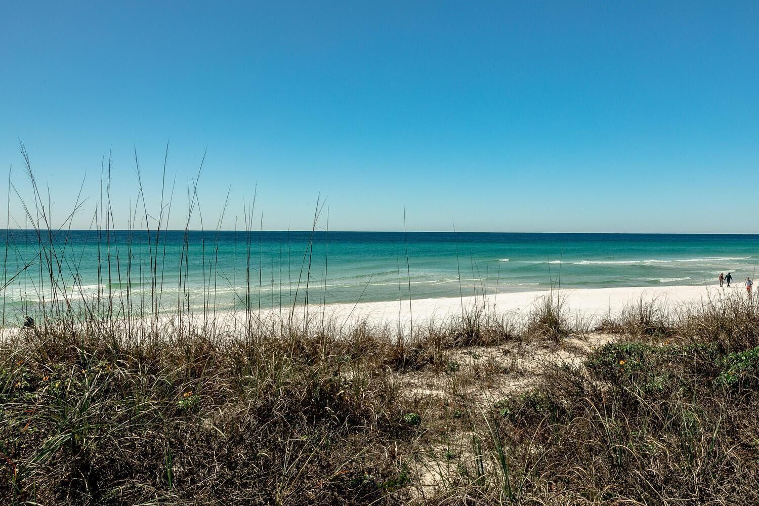 Une plage à l’eau turquoise et au sable blanc.