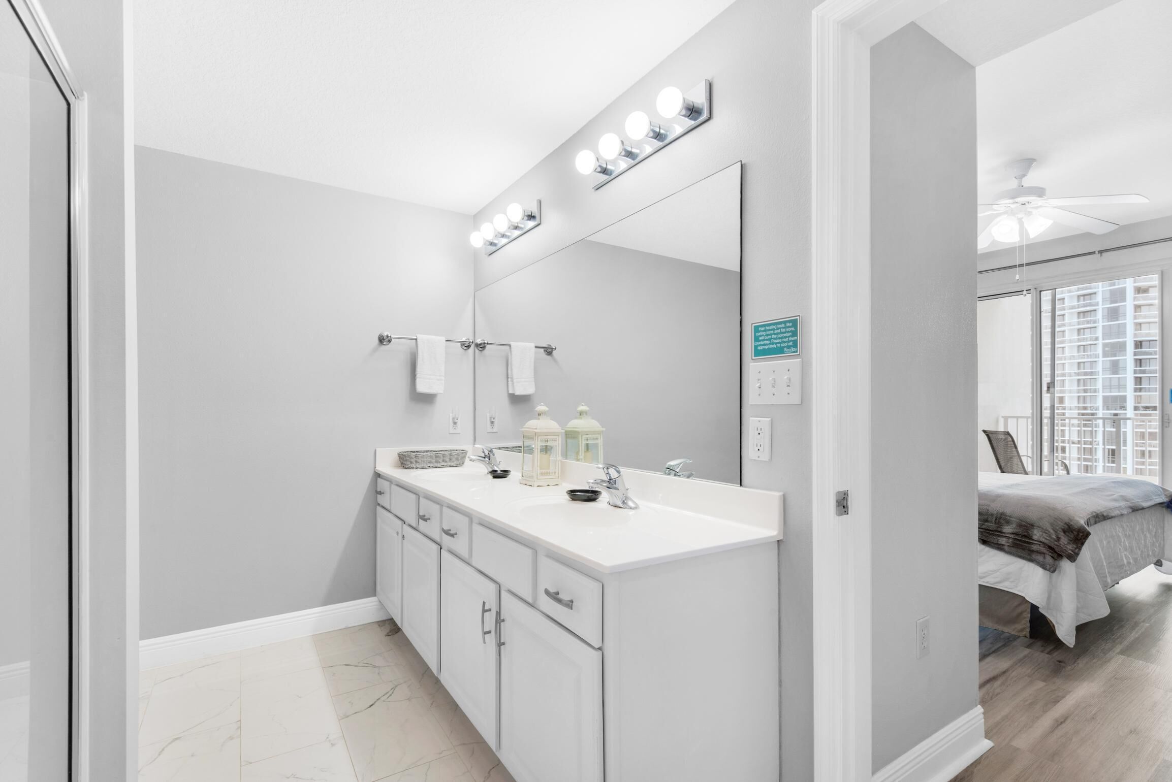 A modern bathroom with a large vanity, mirror, and lighting.