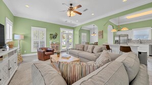A living room with a sofa, a coffee table, a TV, and a ceiling fan. - Drift Away (Santa Rosa Beach)