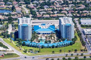 A large hotel with two prominent towers, a central building, and a swimming pool area.