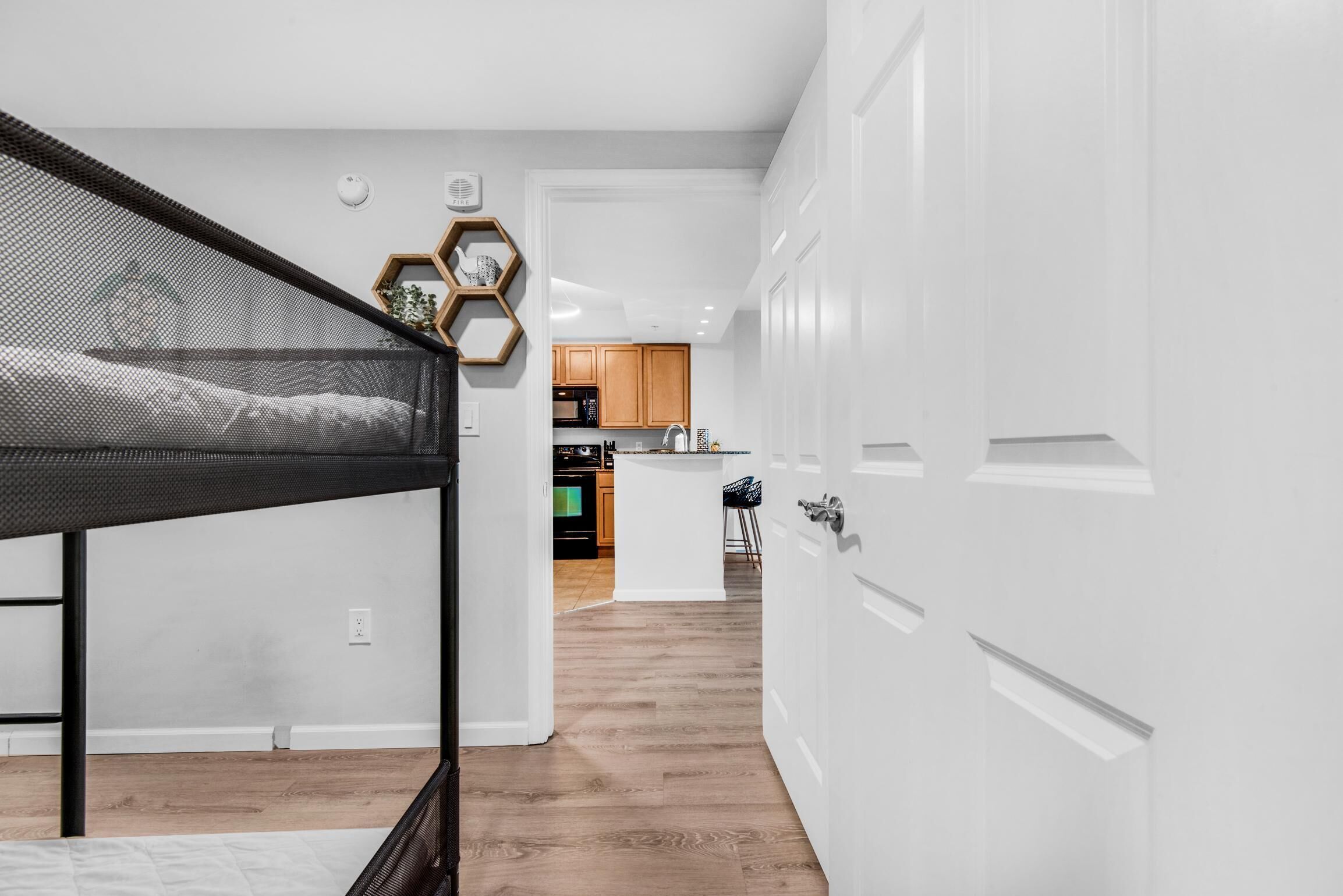 Un interior moderno con una cama litera, una zona de cocina y paredes blancas.