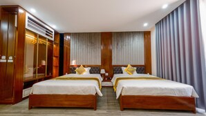 A hotel room with two beds, a wardrobe, and a large mirror. - MIMOSA HALONG HOTEL (Ha Long)