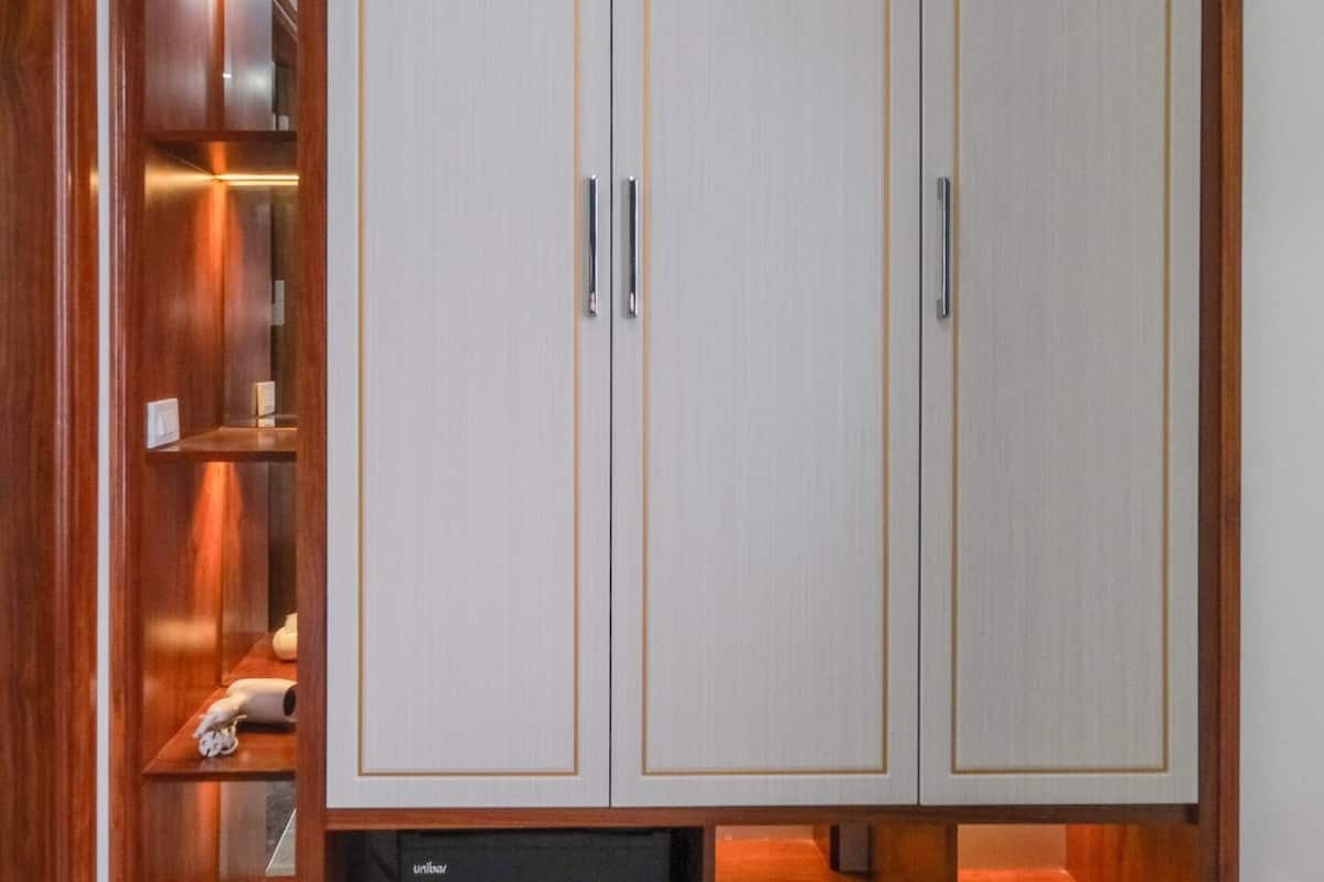 A wardrobe with three doors, a small shelf, and a drawer.
