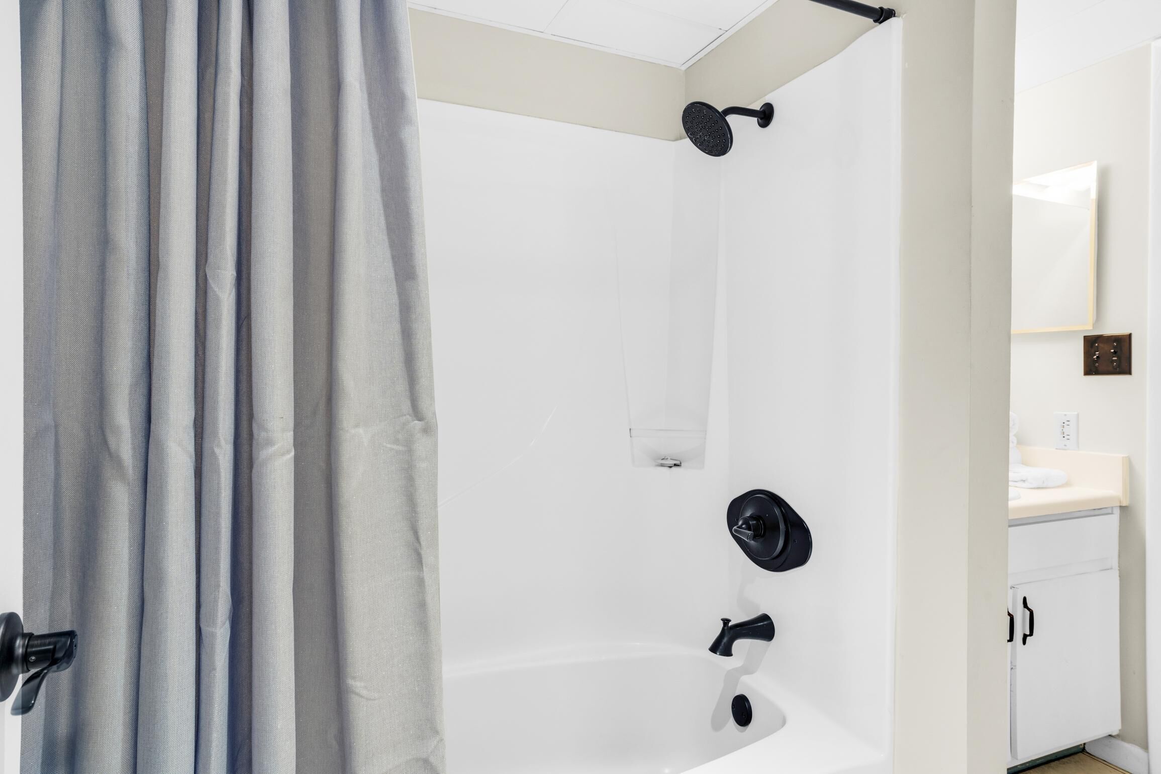 Une salle de bain moderne équipée d’une baignoire, d’une douche et de toilettes.