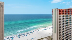 A beach view with a high-rise hotel in the foreground.