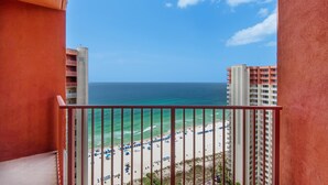A balcony with a view of a beach and ocean.