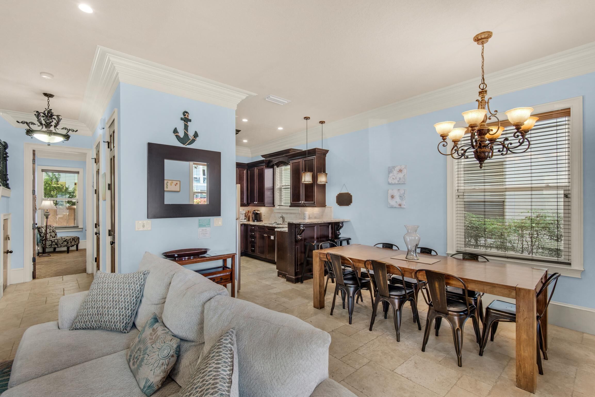 A spacious living room with a sofa and a dining area with a wooden table and chairs.