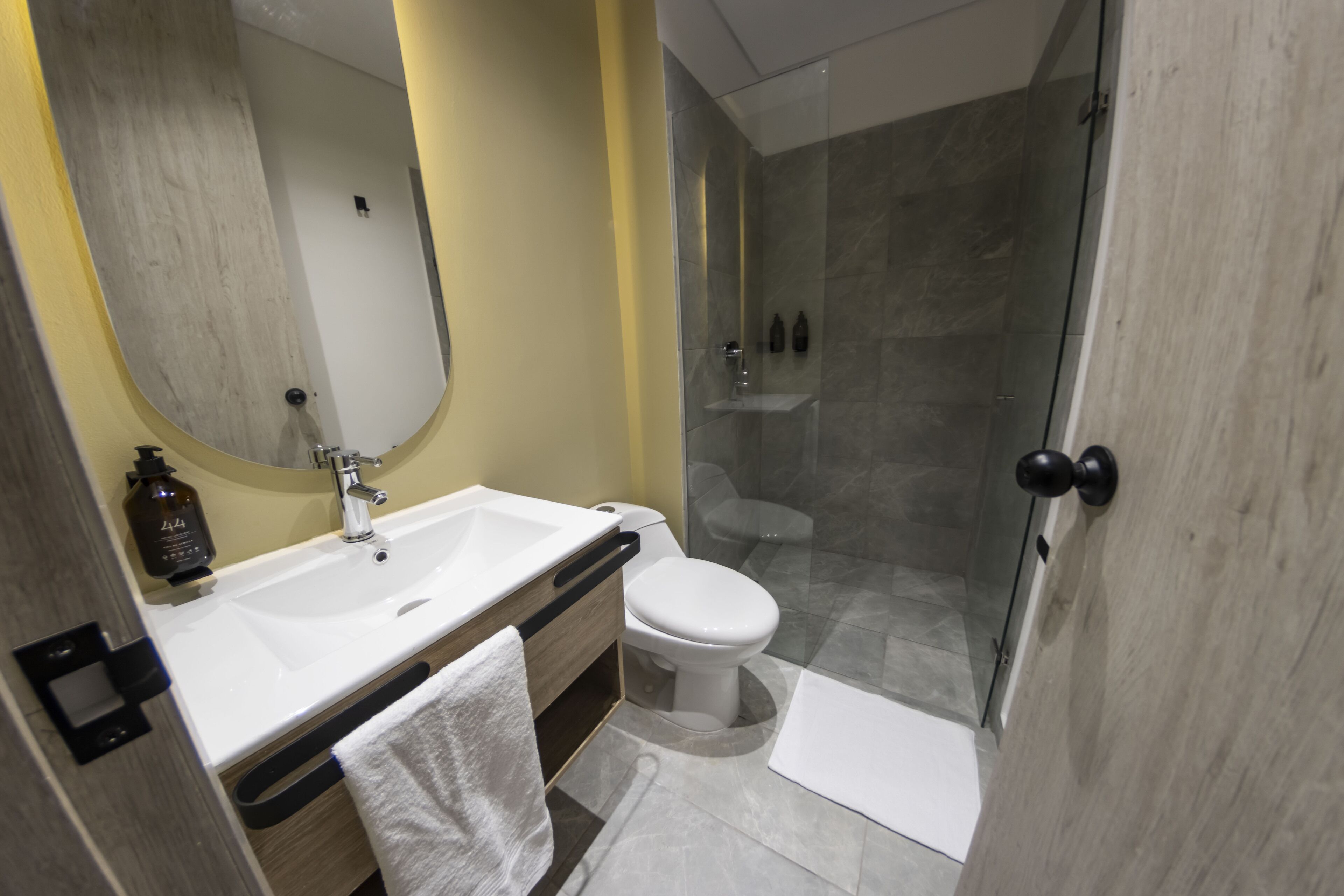 Un baño moderno con un lavamanos grande, inodoro y cabina de ducha de vidrio.