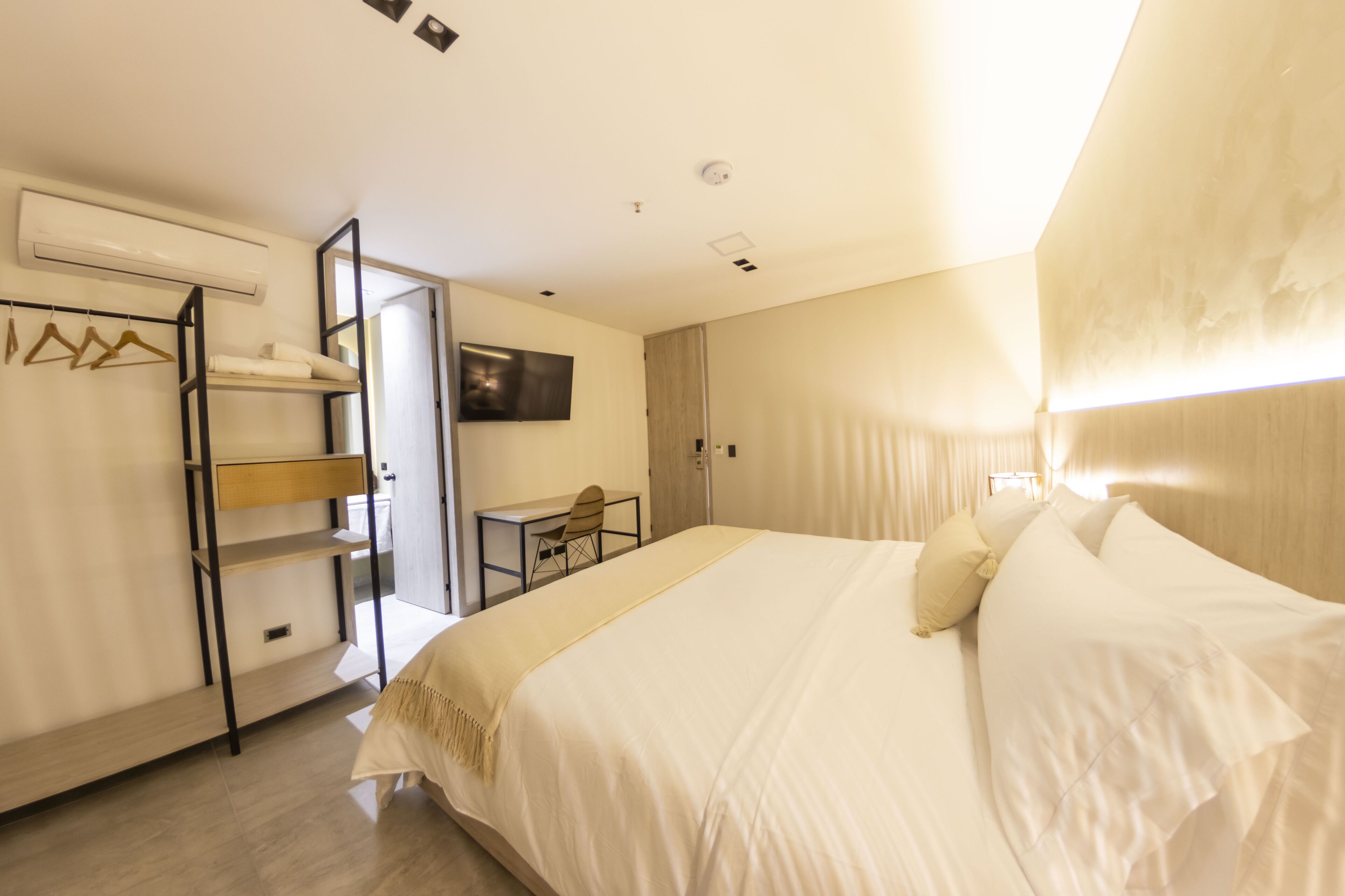 Une chambre d’hôtel comprenant un lit, un bureau, une chaise, une armoire et un téléviseur.