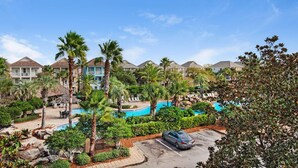 A resort with a swimming pool, palm trees, and a parking area. - Destin's Siren Song (Destin)