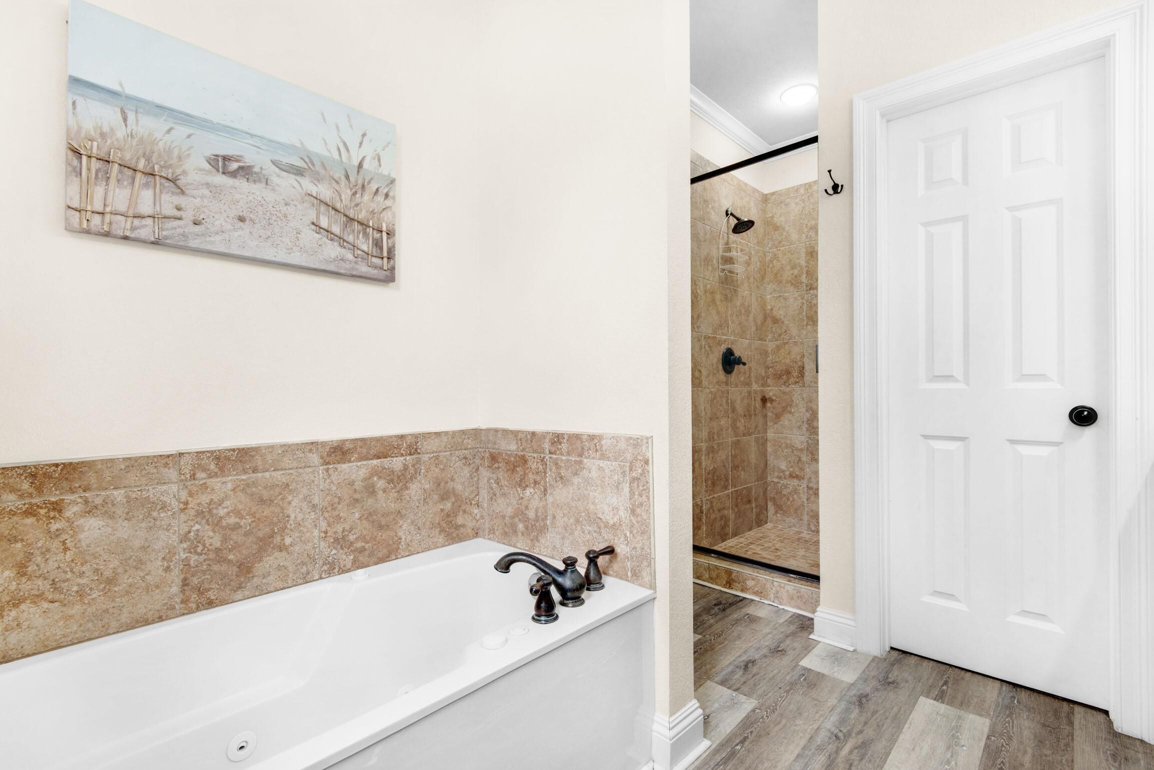 Une salle de bain avec une baignoire, une douche et une porte.
