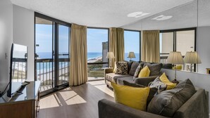 A modern living room with a large window, a sofa set, and a flat-screen TV. - Sundestin 1415 (Destin)