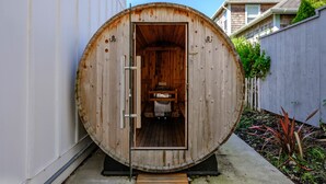 A sauna with a wooden exterior, a door, and a bench inside.