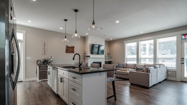 A modern kitchen with a central island, white cabinetry, and pendant lighting.