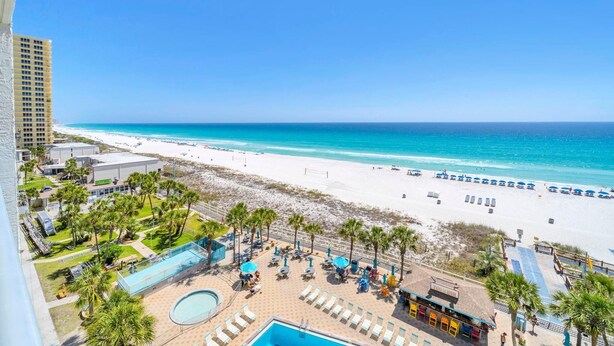 A resort with a pool, lounge chairs, and a beach view. - The Summit 818 (Panama City Beach)