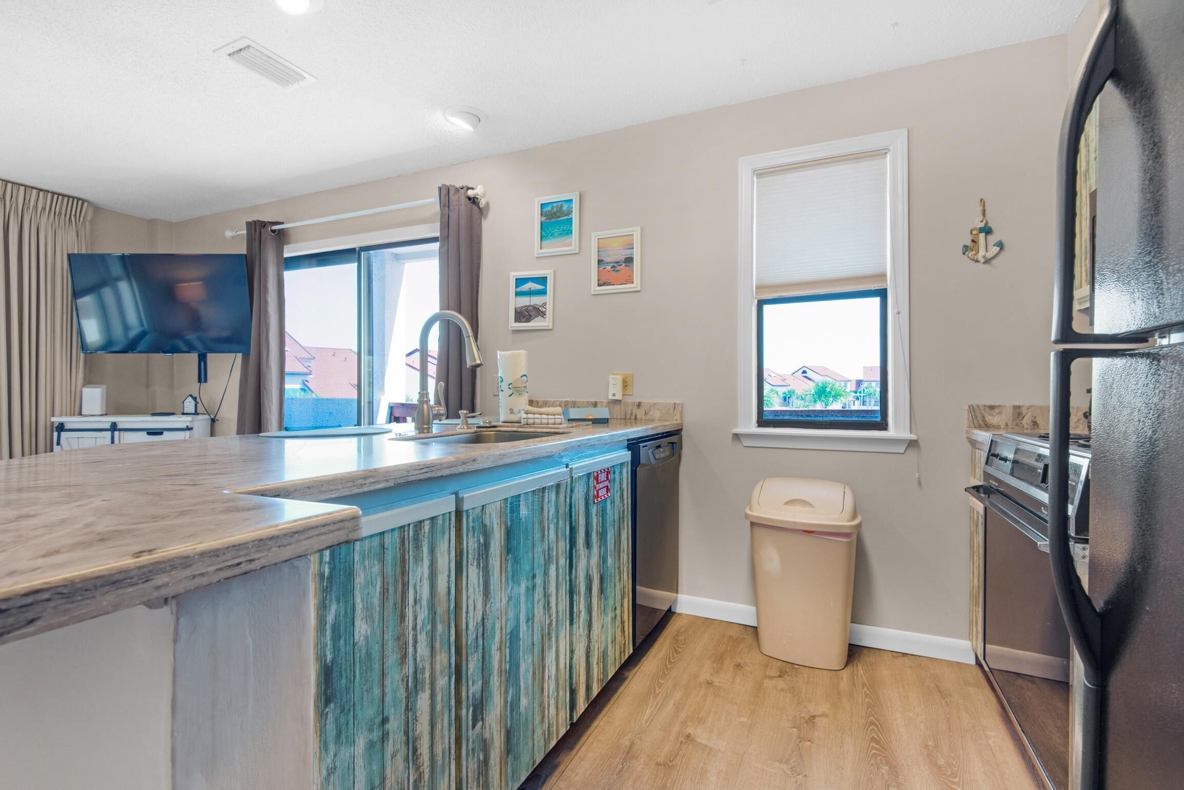 A modern kitchen with a wooden island, stainless steel appliances, and a view of the outdoors.