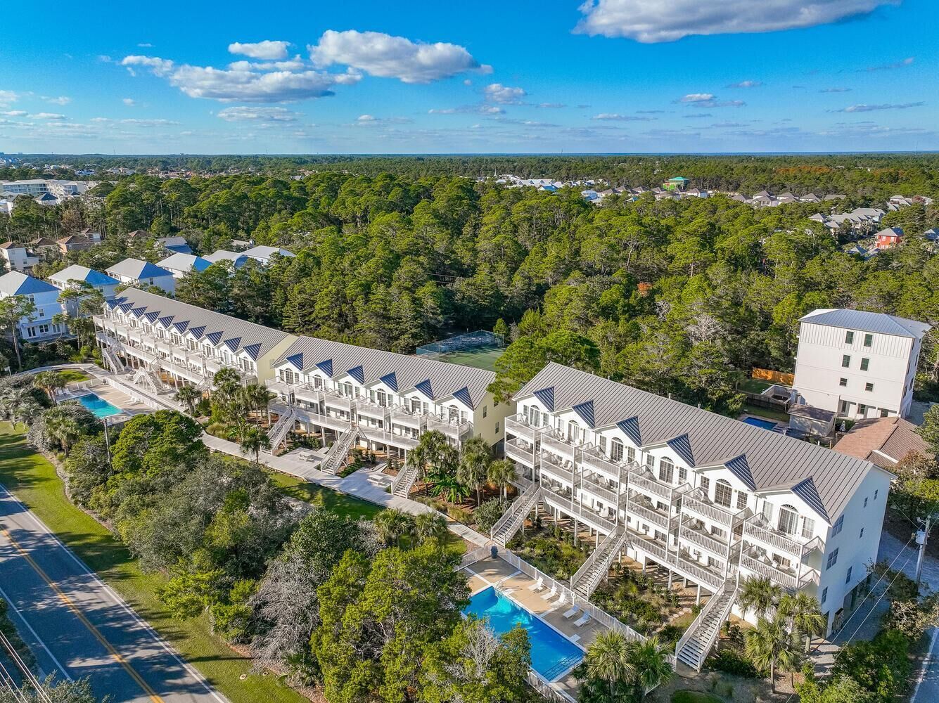 Ein Resort mit mehrstöckigen Gebäuden, einem Schwimmbad und einer entlangführenden Straße.