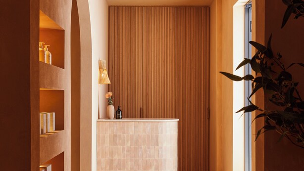Un baño tipo spa con una bañera grande, paneles de madera y piso de baldosas.