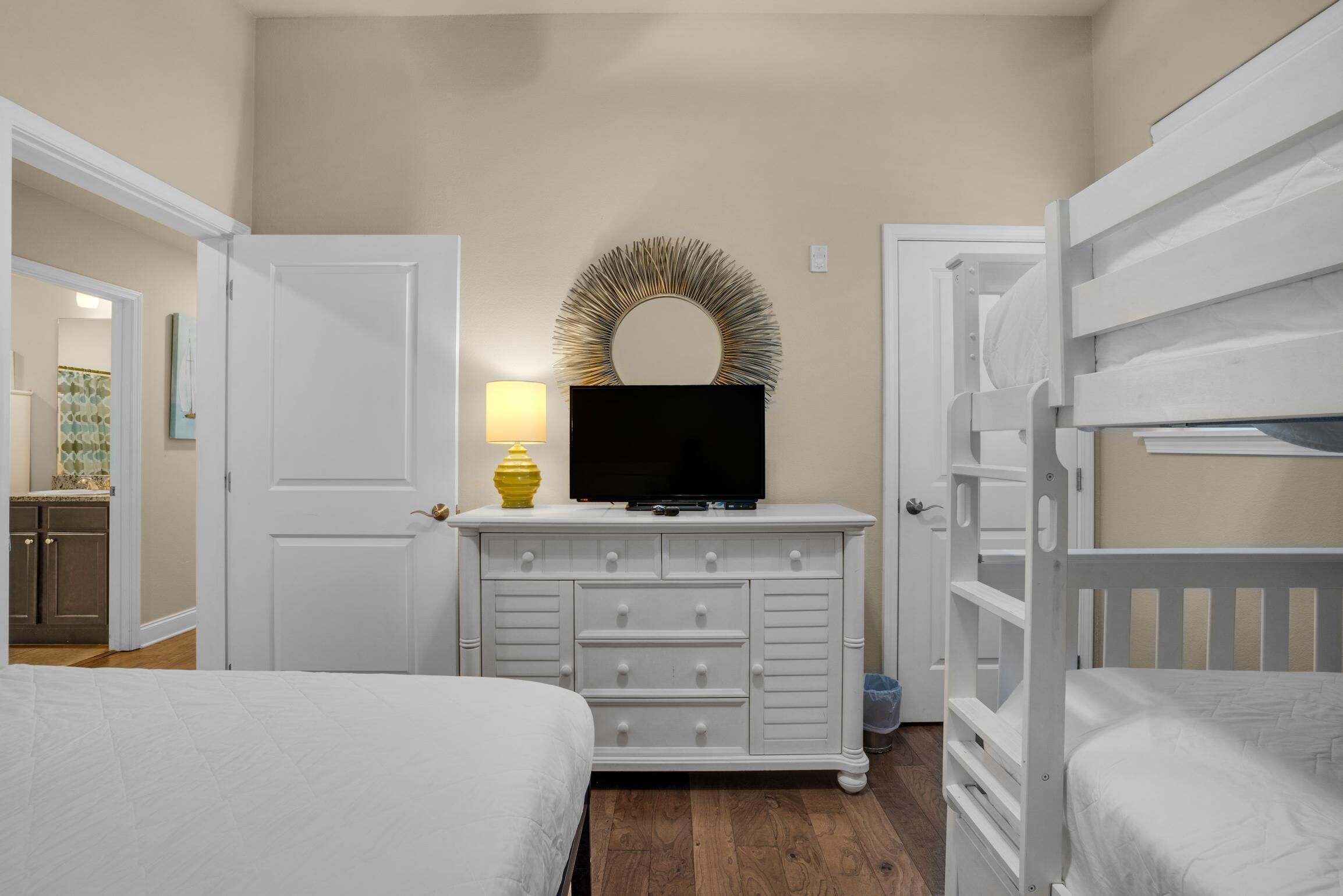 Een slaapkamer met twee bedden, een kaptafel met spiegel en een televisietoestel.