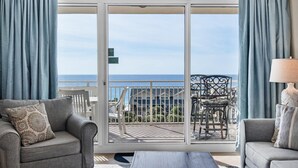 Ein Balkon mit Blick auf den Ozean, ausgestattet mit Stühlen und einem Tisch.