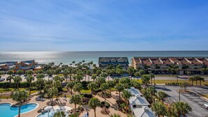 Ein Resort mit Pool, Palmen und Blick auf den Ozean.